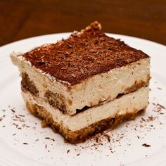 a piece of cake sitting on top of a white plate with chocolate shavings