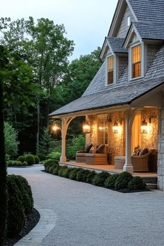 a house with two couches on the front porch and lights on in the windows