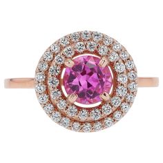 This striking sapphire ring boasts a striking, bubbly, Barbie pink color, perfect for everyday wear. Offered at a spectacular value, this is a fantastic gemstone engagement ring, or right handed statement cocktail ring. With a contemporary rose gold double halo design, we "rescued" an antique 1.07 carat pink sapphire and encircled it with 44 brilliant natural diamonds. Being an antique gem, it shows minor abrasions and a small chip to the edge, visible only under 10x magnification Condition: Setting is new; sapphire is antique (minute abrasions; see description) Era: Contemporary Year: 2024 Metal: 14k Rose Gold Gemstone: Pink Sapphire Carat Weight: 1.07 Cut: Round Color: Pink Clarity: Transparent Accent Diamonds:  44 Round Brilliants 0.25 carats total G-H Color VS Clarity  Graded by GIA st Paraiba Tourmaline Engagement Ring, Barbie Pink Color, Barbie Rosa, Rosa Barbie, Double Rings, New Barbie, Pink Engagement Ring, Pink Sapphire Ring Engagement, Gemstone Engagement Ring