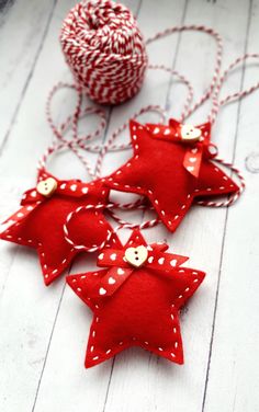 three red felt ornaments with white polka dots on them