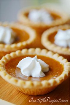 mini pumpkin pies on a cutting board with whipped cream in the center and text overlay that reads mini pumpkin pies