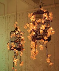 two chandeliers hanging from the ceiling in a room with white flowers on them