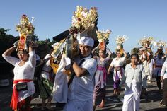 a group of people walking down a street holding onto some kind of headdress