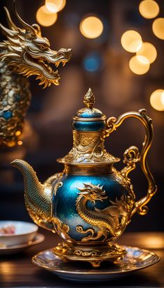 a blue and gold teapot sitting on top of a plate next to a dragon figurine