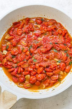 tomato sauce in a white bowl with wooden spoon