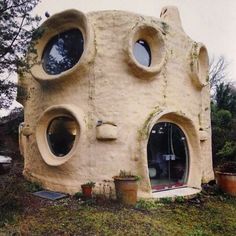 a house made out of rock with round windows