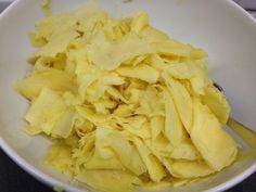 a white bowl filled with yellow food on top of a table