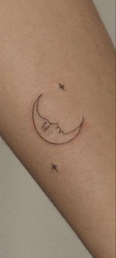 a small crescent and star tattoo on the arm