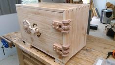 a wooden box sitting on top of a workbench in a shop or workshop