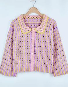 a pink and yellow sweater hanging on a hanger