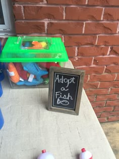 a chalkboard sign sitting on top of a table next to some plastic balls and toys