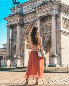 a woman standing in front of a large building