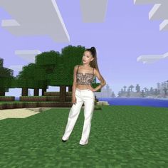 a woman in white pants and crop top standing on a grass field with trees behind her