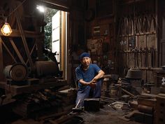 a man sitting in a workshop with tools