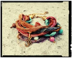 "Bohemian Wrap Bracelet in a Colorful Sari Silk Mix. Gold Rings, Natural Stone Beads and a Golden Om Charm. Lobster Clasp with 2\" Extension Chain allows for a perfect fit for any wrist size. You may leave your wrist measurement if you prefer. *Custom Orders Welcome* Gift Box, Extras, etc... May be purchased in the Ala Carte Listing. https://www.etsy.com/listing/286913011/ala-carte-ordersadd-onsextras-stainless" Sari Silk Jewelry, Boho Jewelry Diy, Silk Wrap Bracelets, Om Charm, Silk Bracelet, Silk Jewelry, Fabric Bracelets, Unique Jewelry Gifts, Stone Bangle