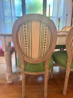 a dining room table and chairs with green cushions