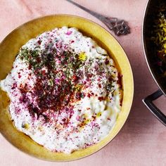 two bowls filled with food next to each other on a pink tableclothed surface