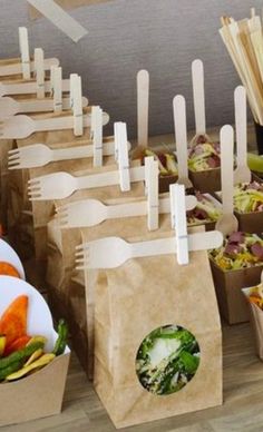 there are many different food items on the table and one is in brown paper bags