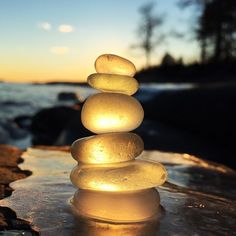 a stack of rocks sitting on top of a beach next to the ocean