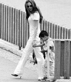 a woman walking next to a little boy