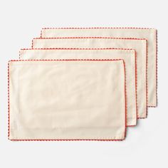 three placemats with red trim on them