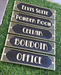 four signs that are on the grass in front of each other and one is pointing to different rooms