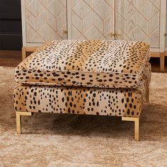 a leopard print footstool sitting on top of a carpeted floor next to a cabinet