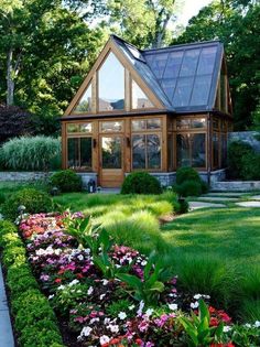 the house is surrounded by lush green grass and flowers