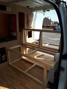 the back end of a van with wooden furniture in it's cargo area and windows