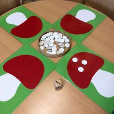 a wooden table topped with lots of paper cut outs and dices on top of it