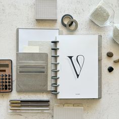 an open notebook sitting on top of a table next to other office supplies and items