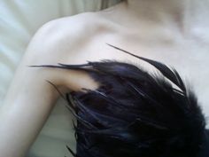 a woman with black feathers on her chest