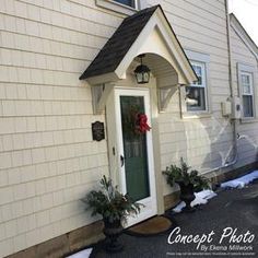 a white house with a green front door and wreath on the side entrance to it