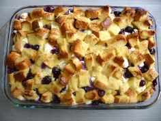 a casserole dish filled with blueberries and bread