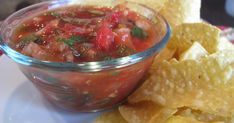 a bowl of salsa and tortilla chips on a plate