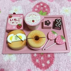 a pink tray filled with donuts and desserts