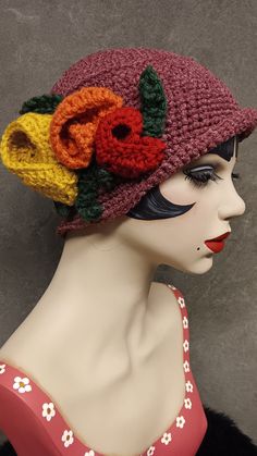 a mannequin head wearing a crocheted hat with flowers on it