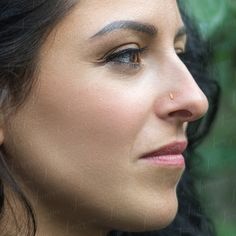 a close up view of a woman's face with her nose piercings on