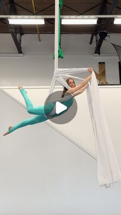 a woman is suspended upside down on a pole