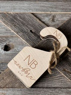 two wooden tags tied together with twine on top of a wood planked floor