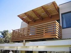 a wooden balcony on the side of a house