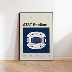 an art and stadium poster hangs on the wall in front of a wooden flooring area