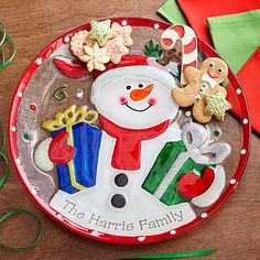 a red plate with a snowman and presents on it