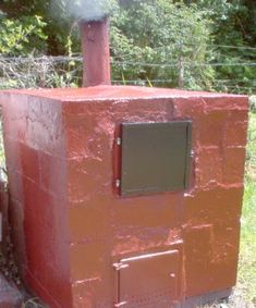 a red brick oven sitting in the middle of a field