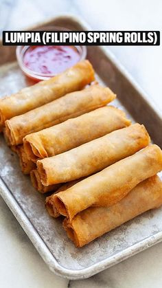 some food is sitting on a tray and ready to be eaten with dipping sauce in the background