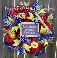 a red and blue mesh wreath with school bus decorations on it that reads, mrs brown 1st grade room 205