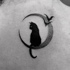 a black cat sitting on top of a crescent tattoo