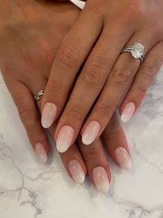 a woman's hands with french manies and a diamond ring on her finger