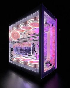 an illuminated display case in the dark with pink and purple lights on it's sides