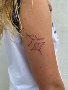 a woman's arm with a tattoo on it that has an image of a bird flying through the sky